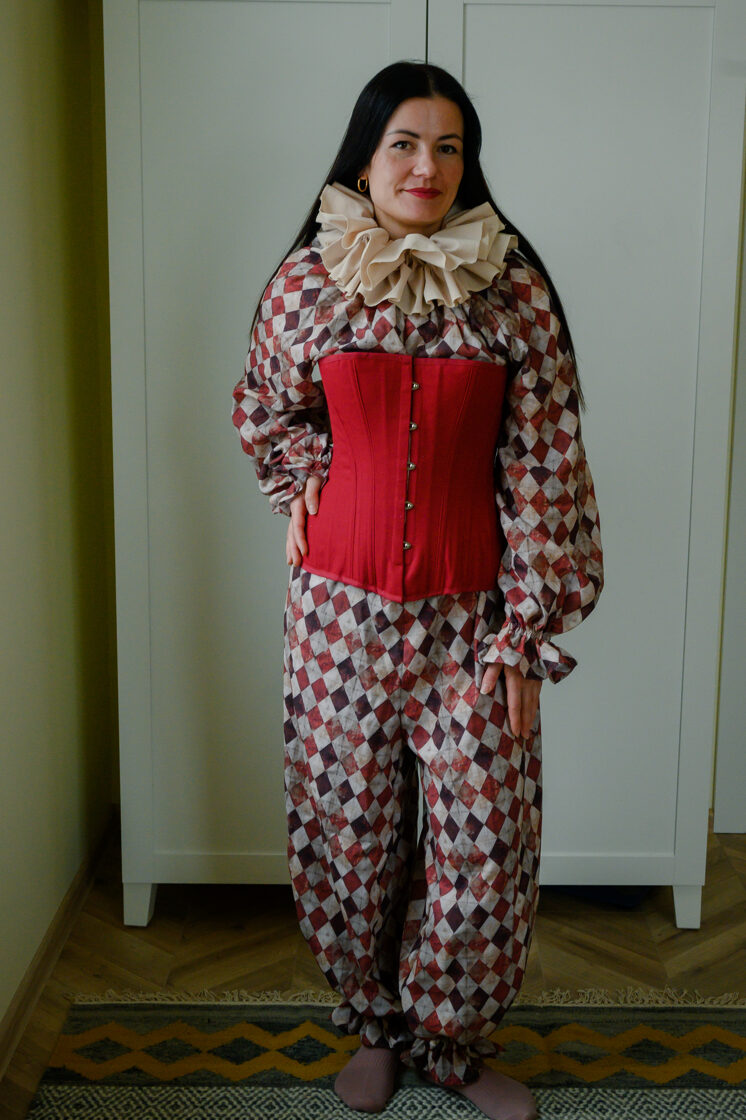 Harlequin pattern clown suit paired with an underbust corset, whimsical vintage circus fashion styling